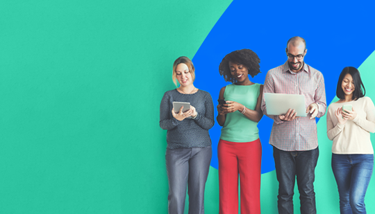 Four people are standing in front of a green and blue background using various electronic devices.